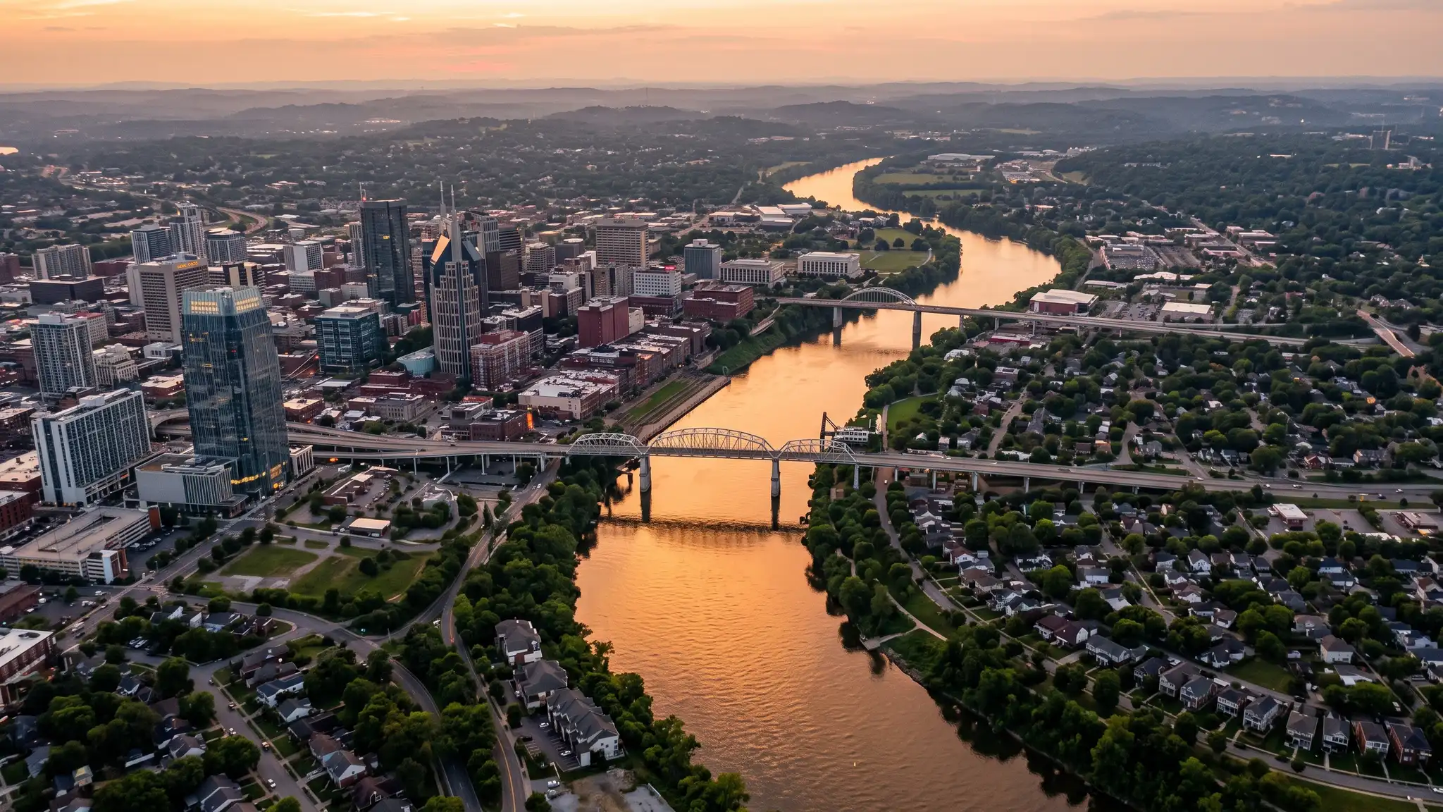 Landscaping service areas | Nashville and Middle Tennessee Aerial view of the Cumberland River winding past the Nashville skyline and residential neighborhoods at sunset with golden light on the water